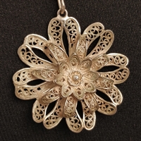 blomst i filigran sølvfarvet metaltråd vedhæng i halskæde gammelt smykke